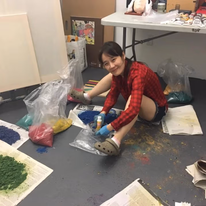 photo of kun working in her studio with pigments