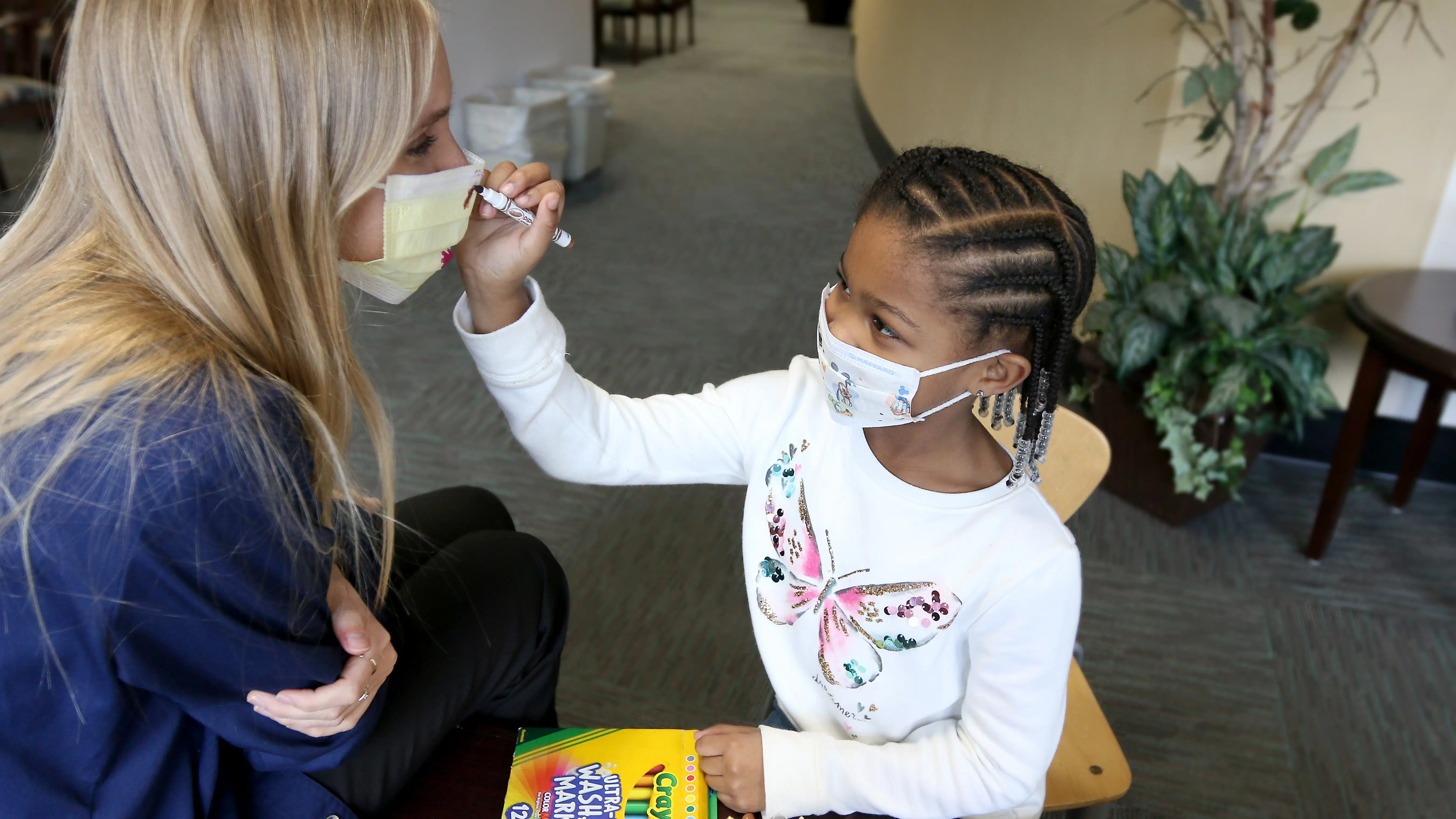 Student and teaching both wearing masks.