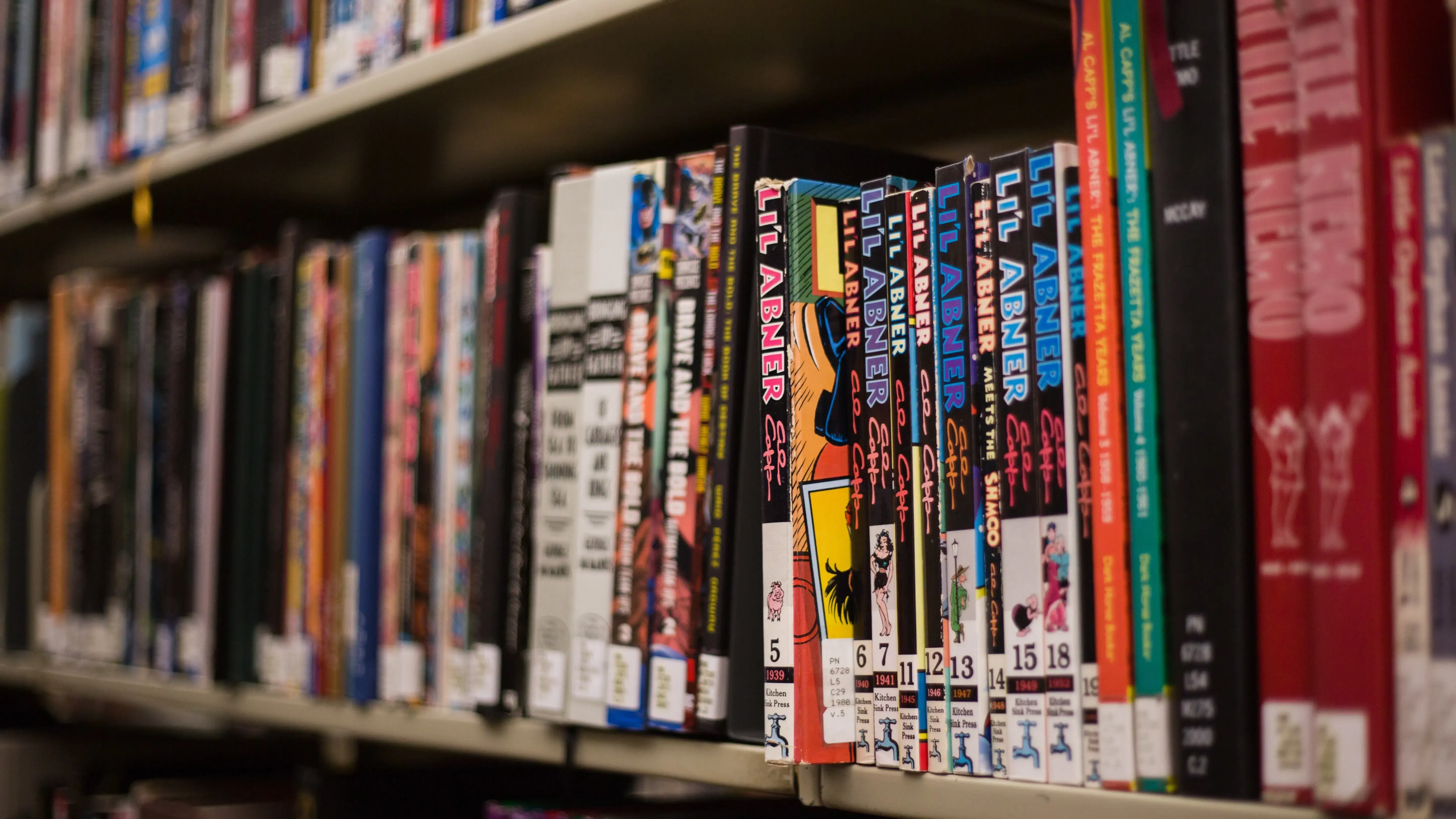 A shelf in a library full of comic books