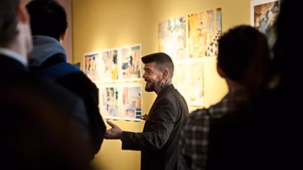 A group of people in front a wall filled with cartoon art.