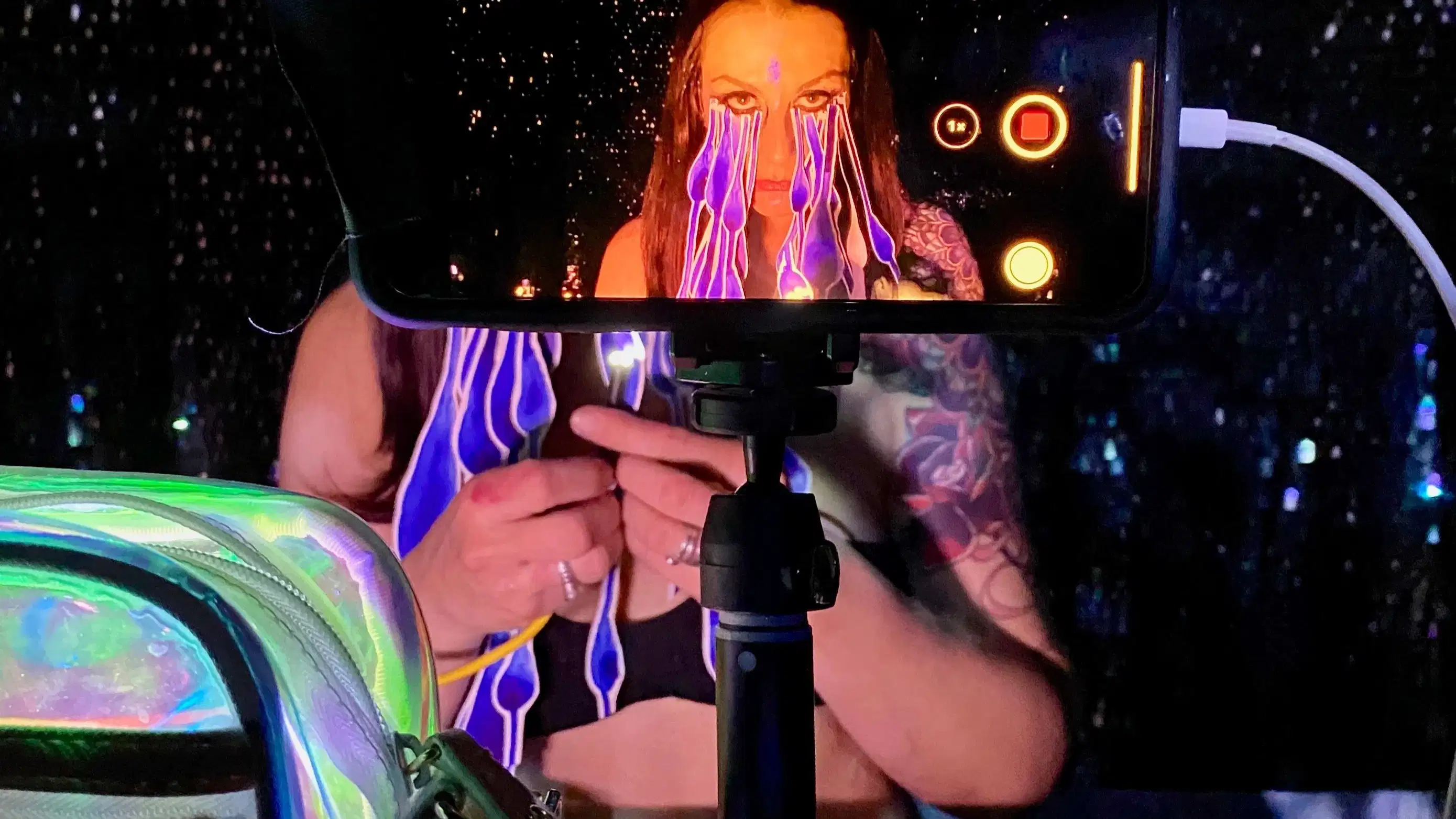 Photographic image of an iphone on a stand taking video of a woman.