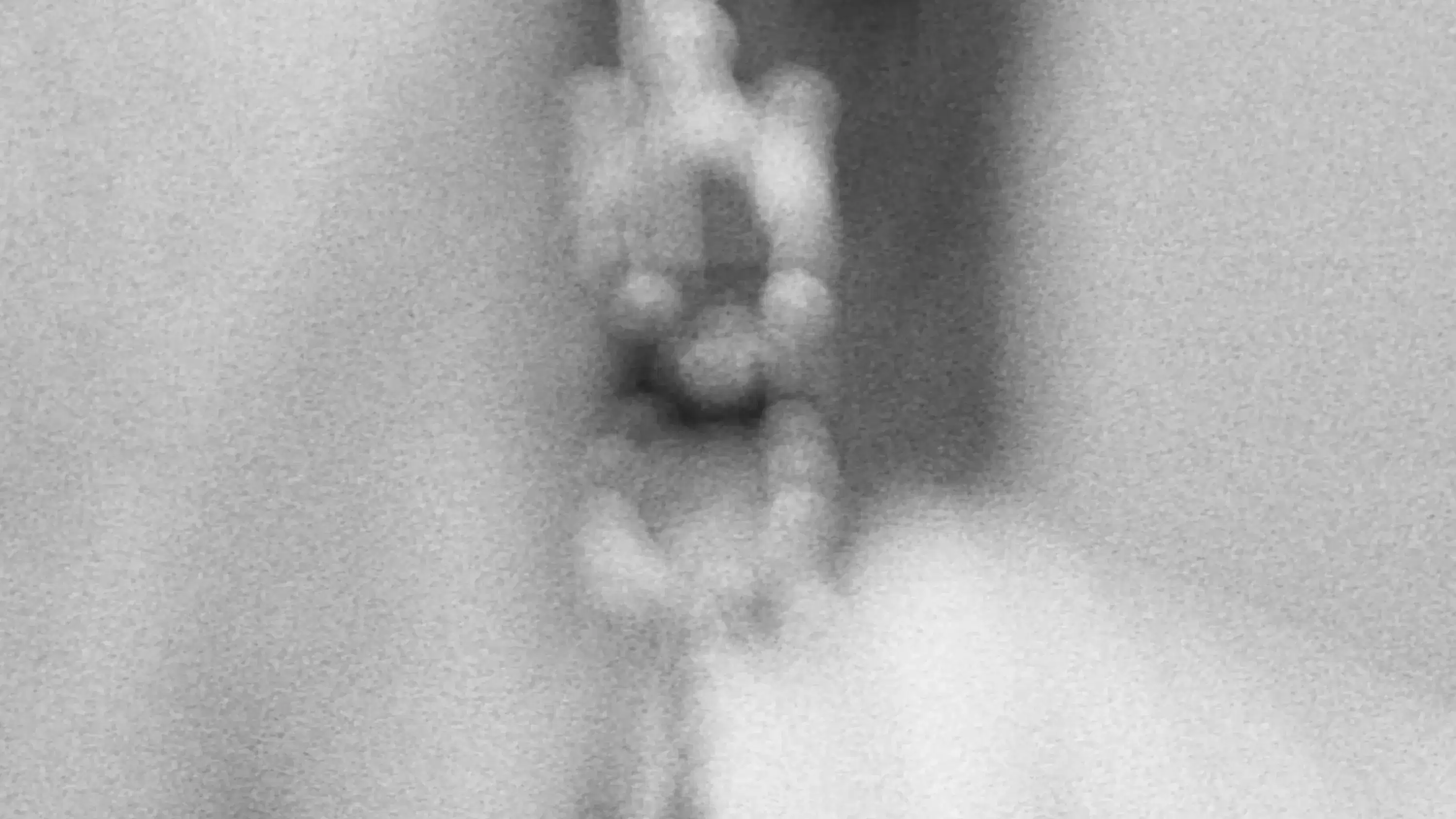 Blurry black and white photography of a dangling earring.