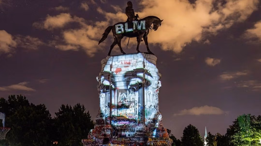 Photo by Kris Graves. A peaceful group gathers at the Robert E. Lee Monument in Richmond, Virginia. Erected in 1890, this is a statue memorializing Virginian Confederate General Robert E. Lee.