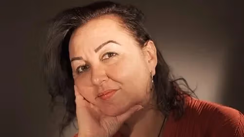 a person poses with their head in their hands