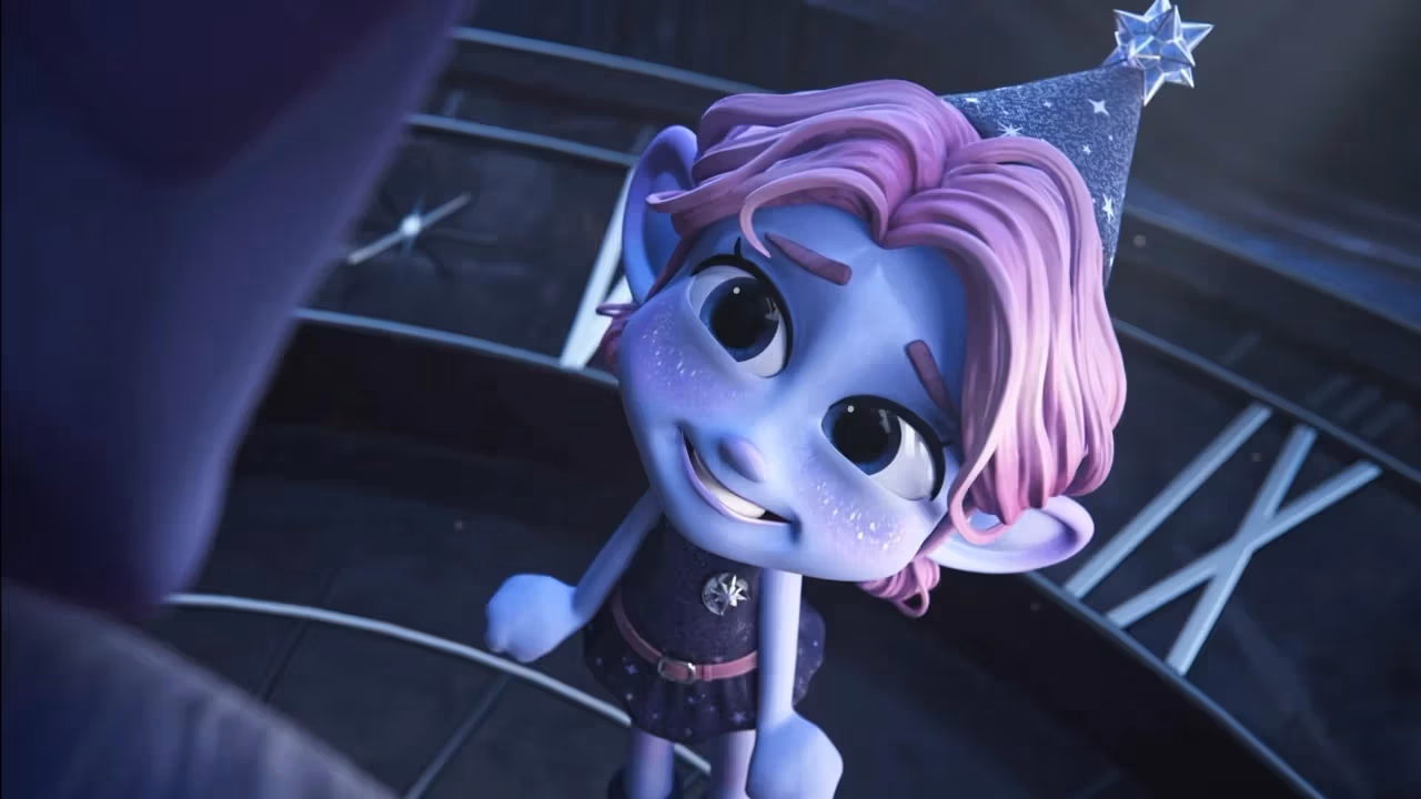 Small, purple, elf-like figure wearing a party hat has a chipper expression while smiling at an obscured figure in the foreground.