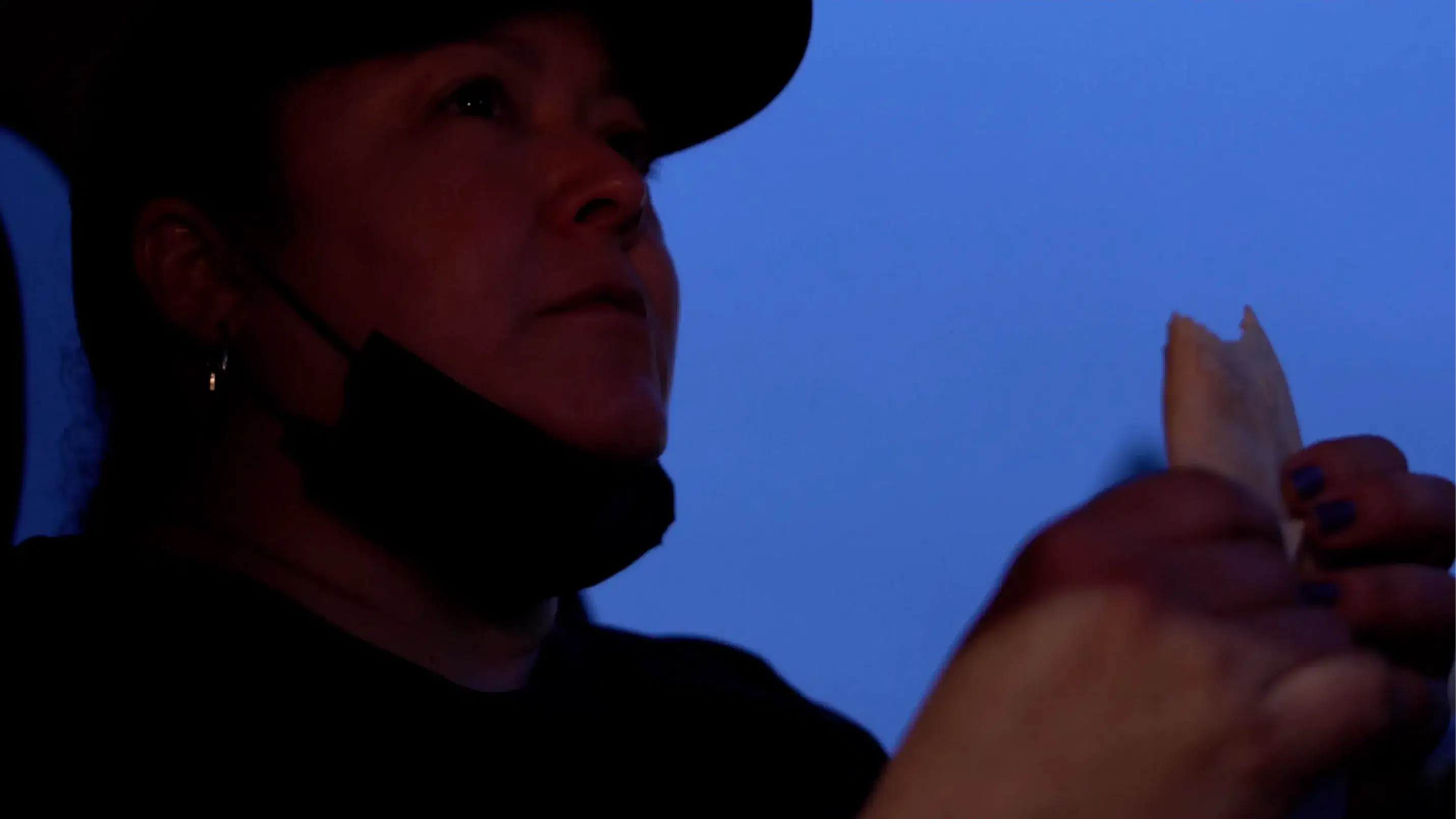 Woman sitting in front seat of car against dark blue sky 