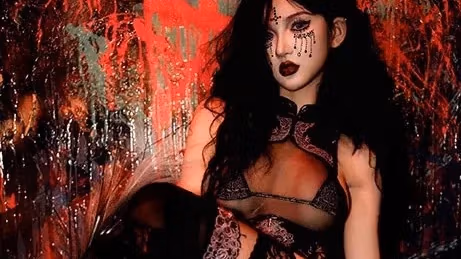 A woman in black lingerie sits with her legs crossed.