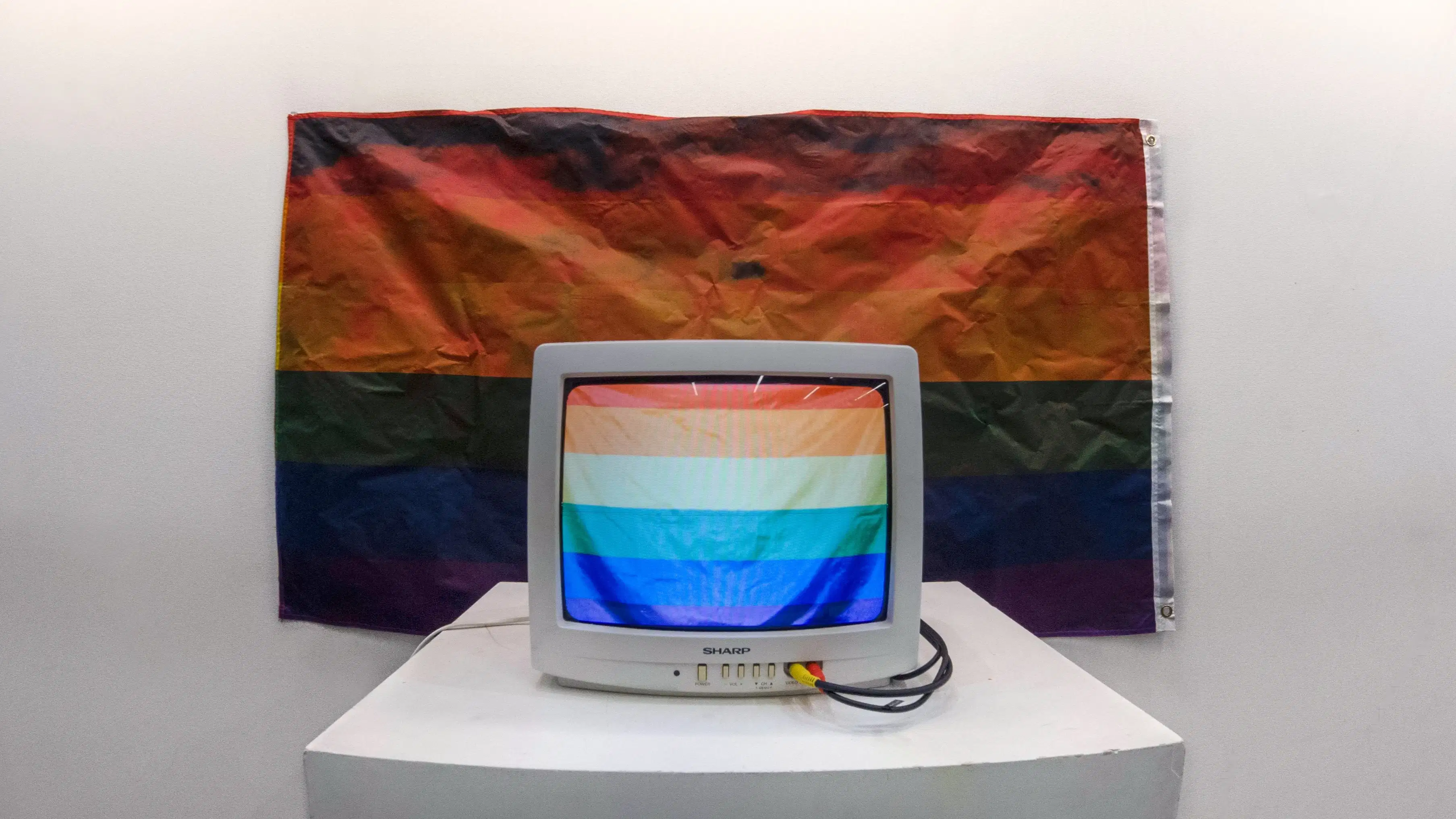 TV with rainbow flag and raindbow flag behind tv