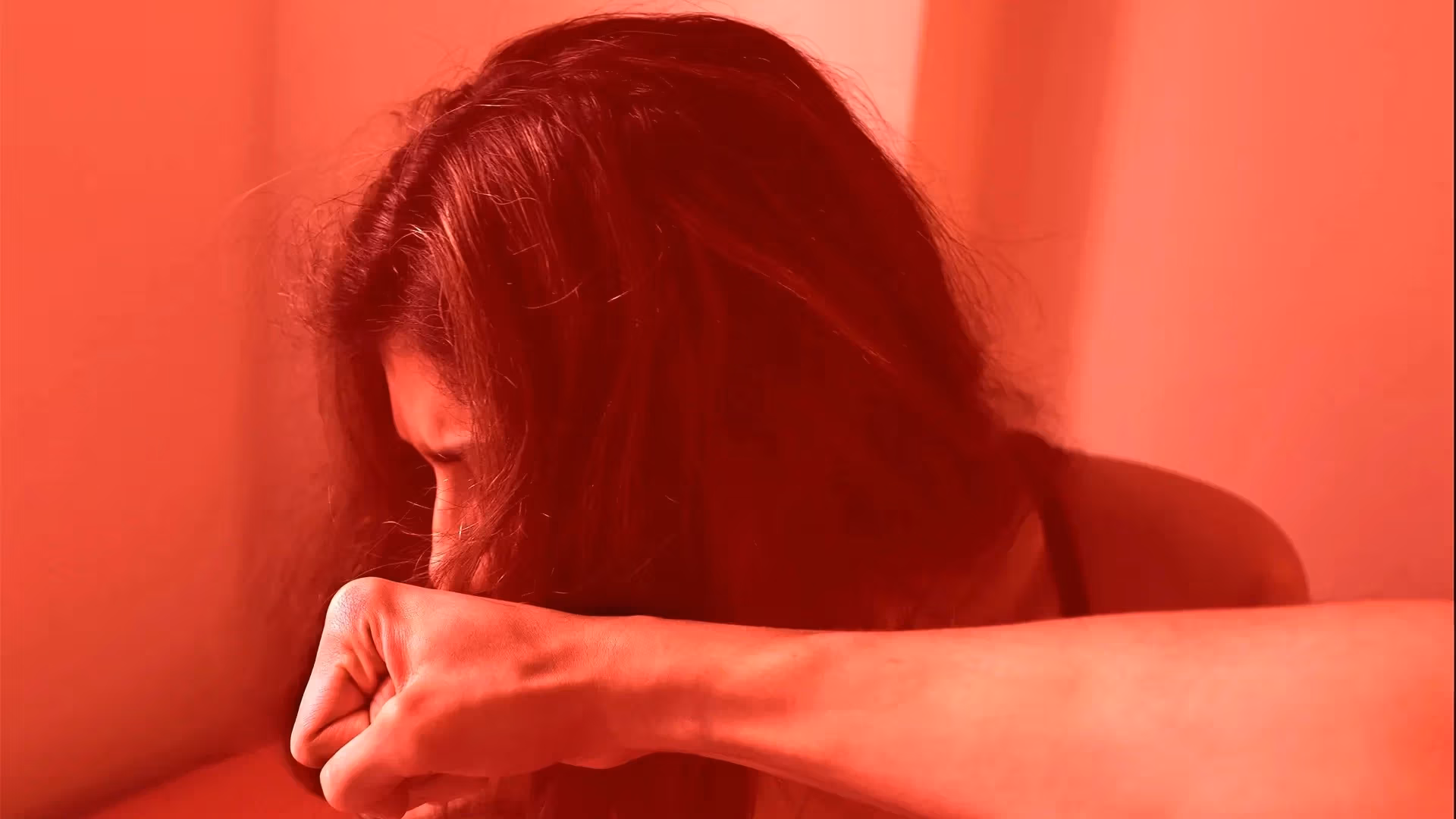  A Red-tone photo of an Indian woman being punched in the face by a man as men consider menstruation to be impure in India. 