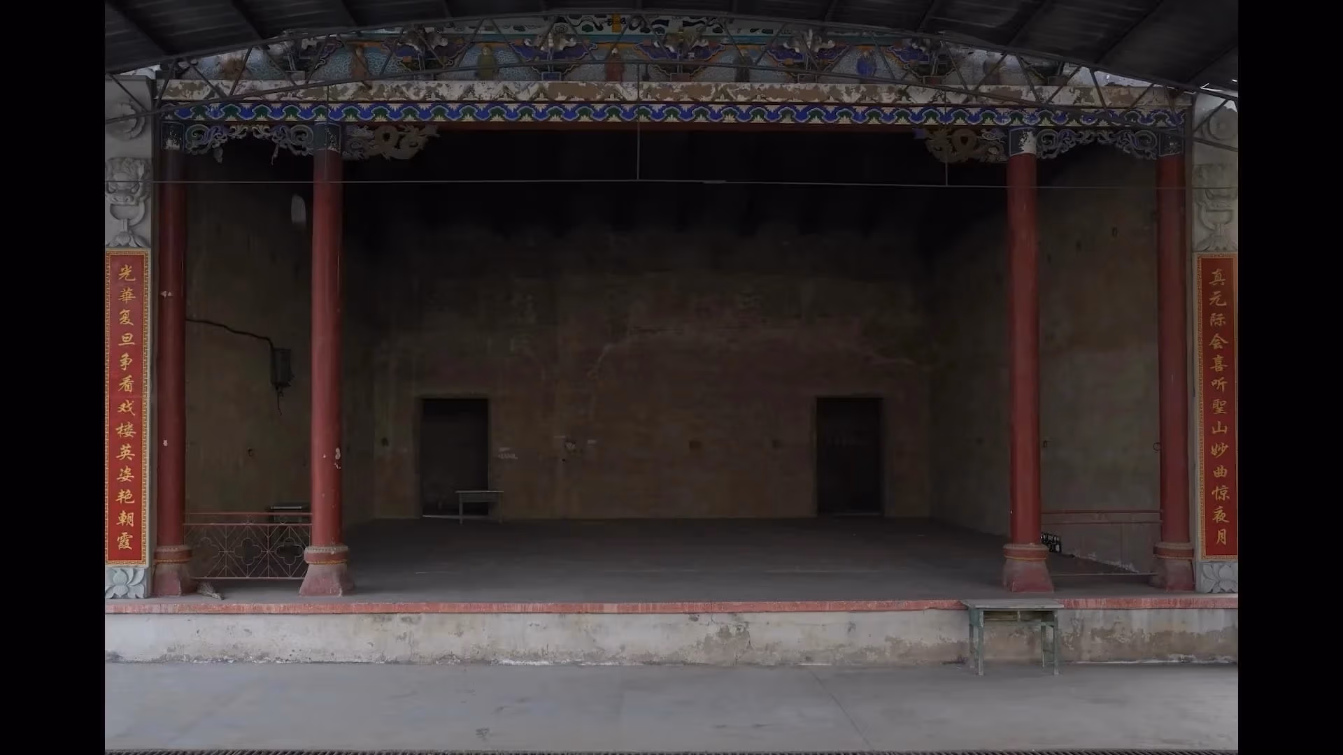 A grey and red buliding with pillars.