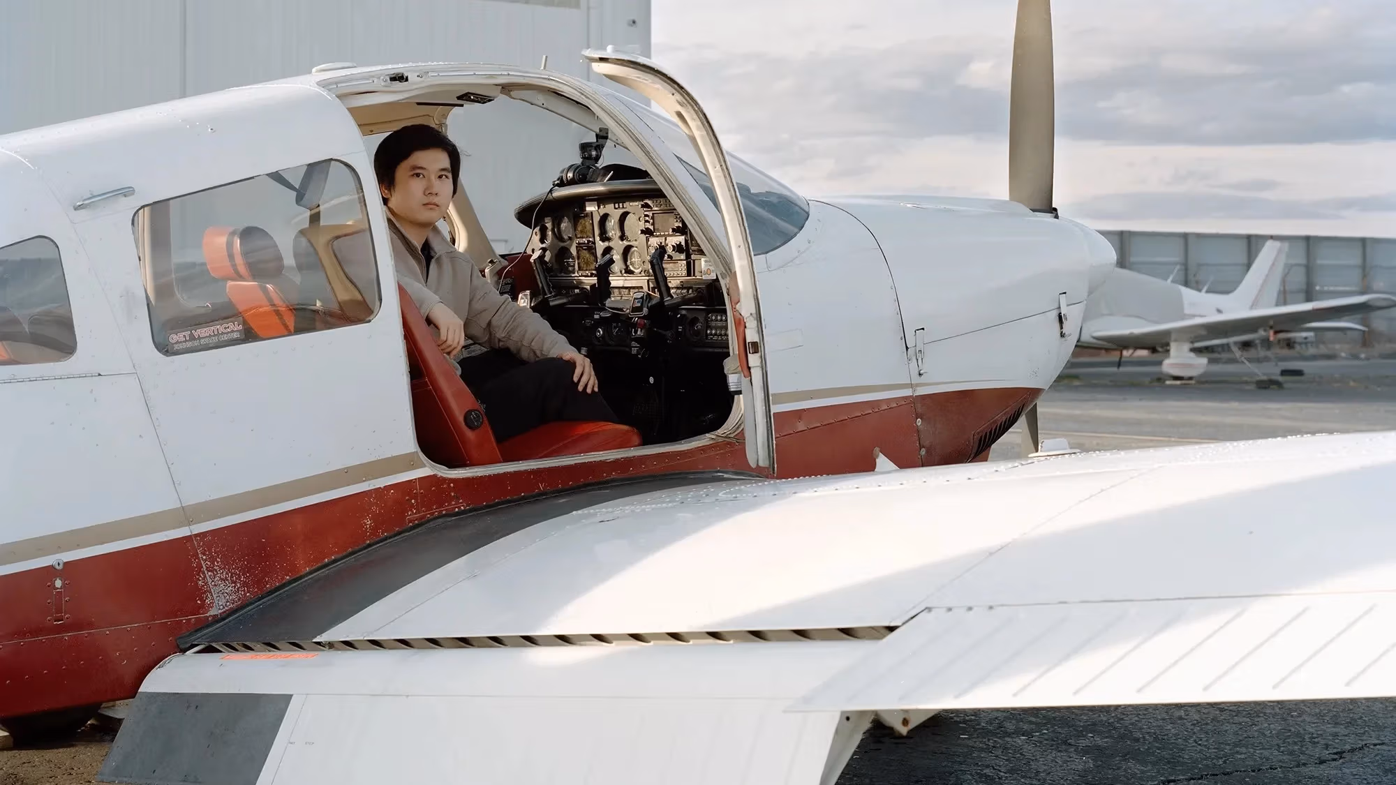 A man sitting in the cockpit of a small plane