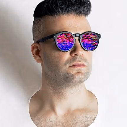 A straight-on portrait of Jon Newman wearing sunglasses with a bright, multicolor pattern in the lenses