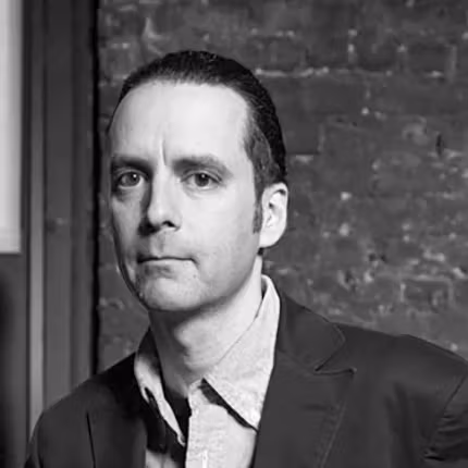 person in  a suit not smiling looking at the camera