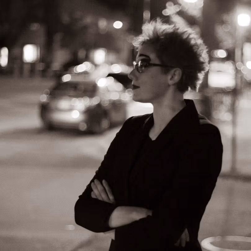 Black and white portrait of Anna Eveslage outside at night on a city street