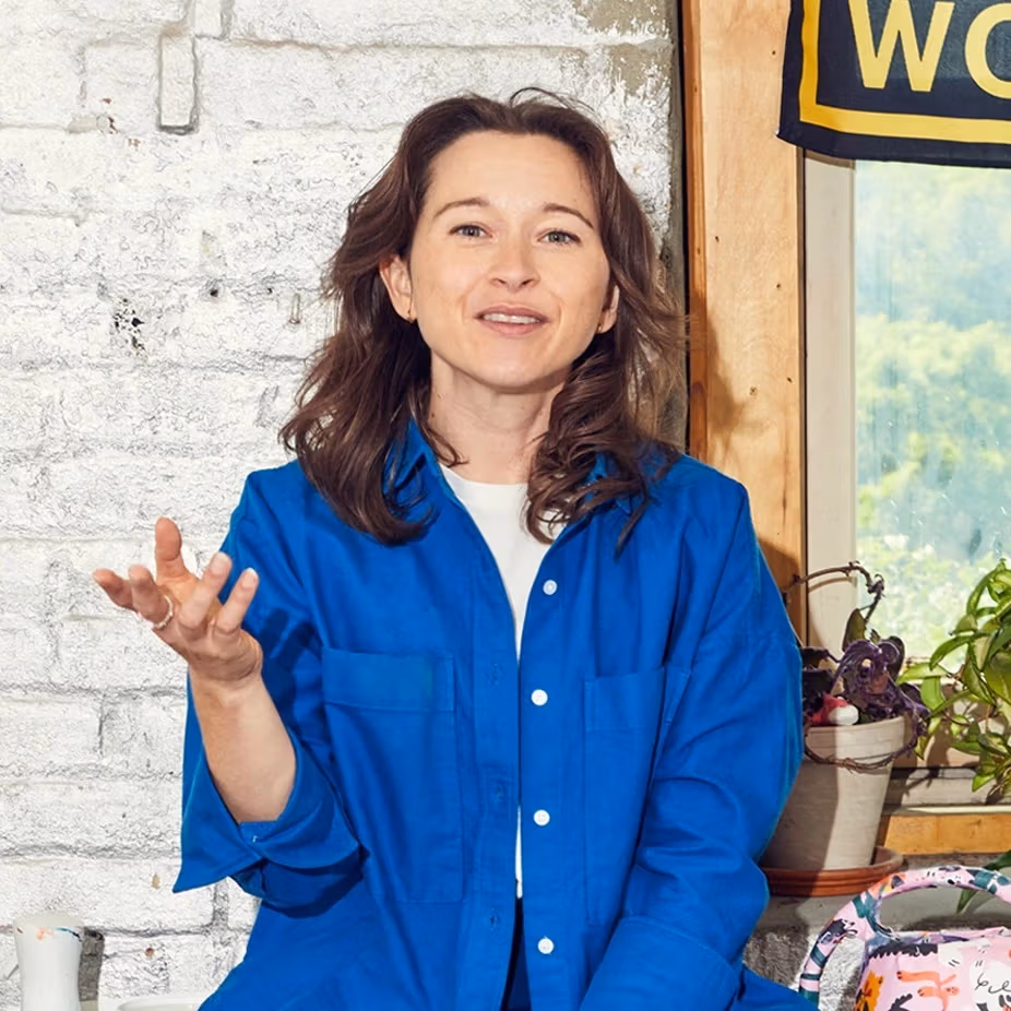 Photo of woman in blue shirt gesturing to camera