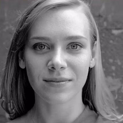 person with long blonde hair looking at the camera