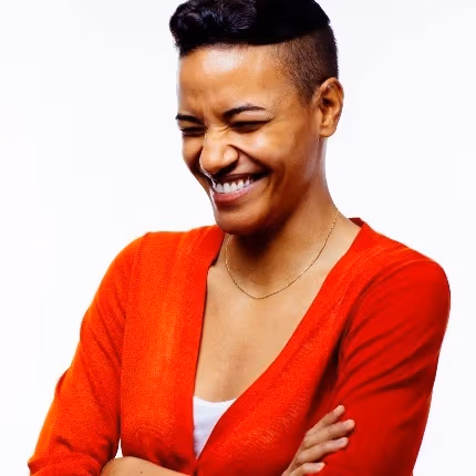 Glendalys Medina smiling in a red shirt with arms crossed 