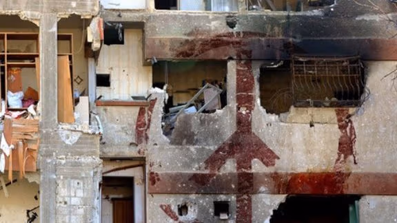 Building with peace sign falling apart