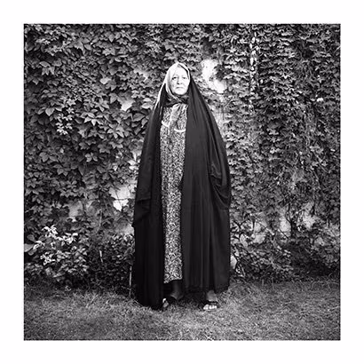 An old woman wearing a cape