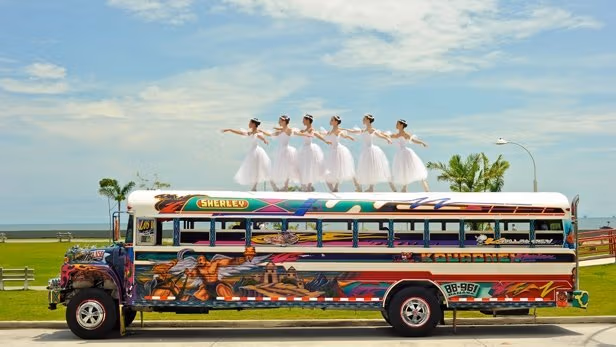 Six girls are dancing on top of the bus
