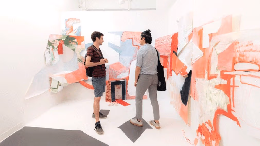 two people standing in front of an installation