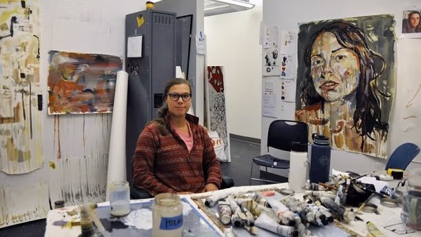 An artist sitting in her studio.