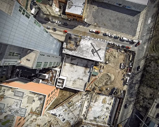 Birds eye view picture of a building and what looks like a construction site