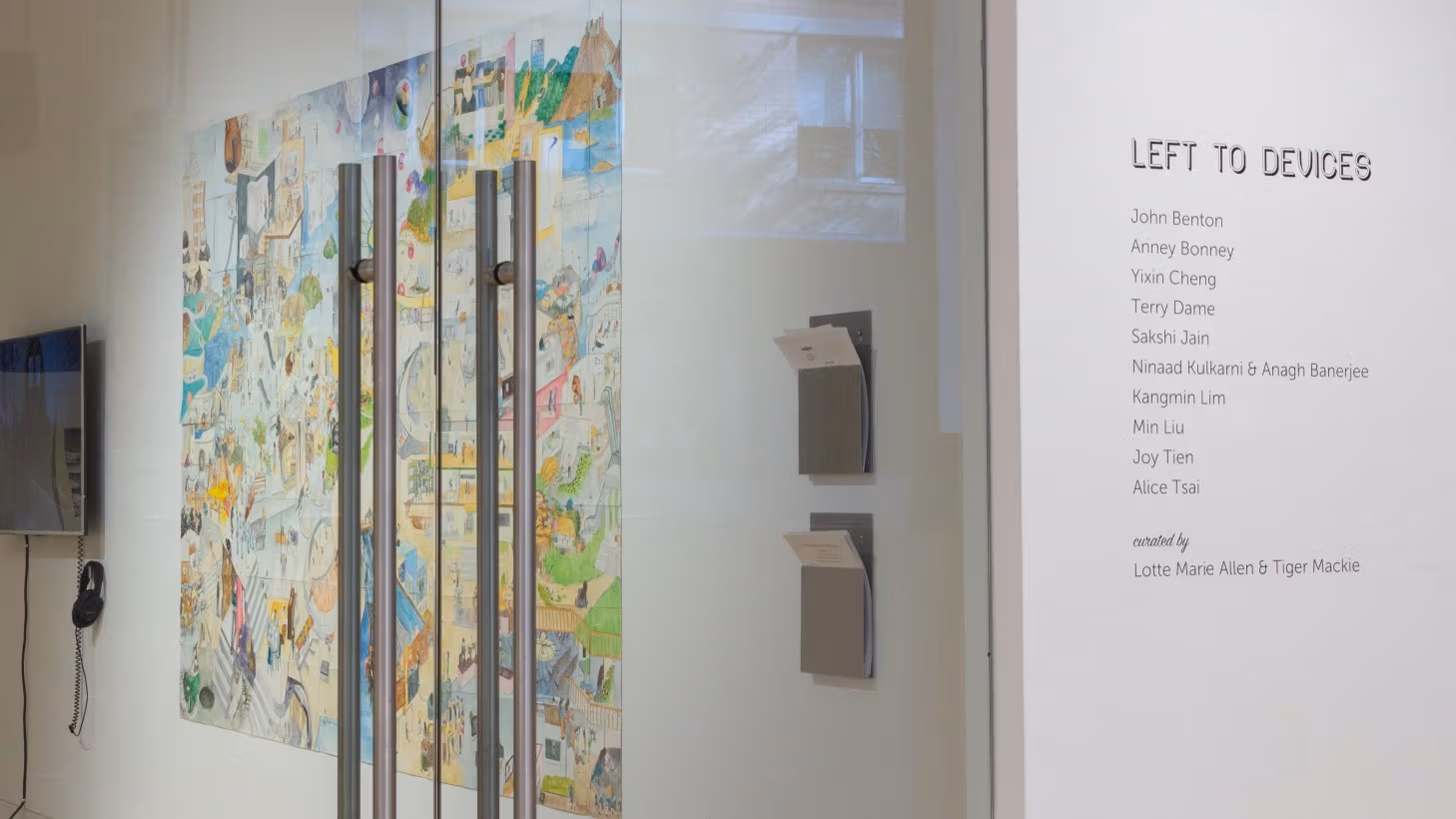 View from right outside primary gallery space, with exhibition title and artist names applied to wall beside door.