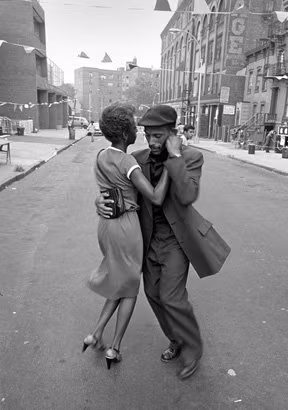 A woman and man dancing together in the street.