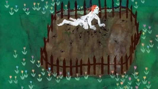 a man sitting in a fenced area in a meadow.