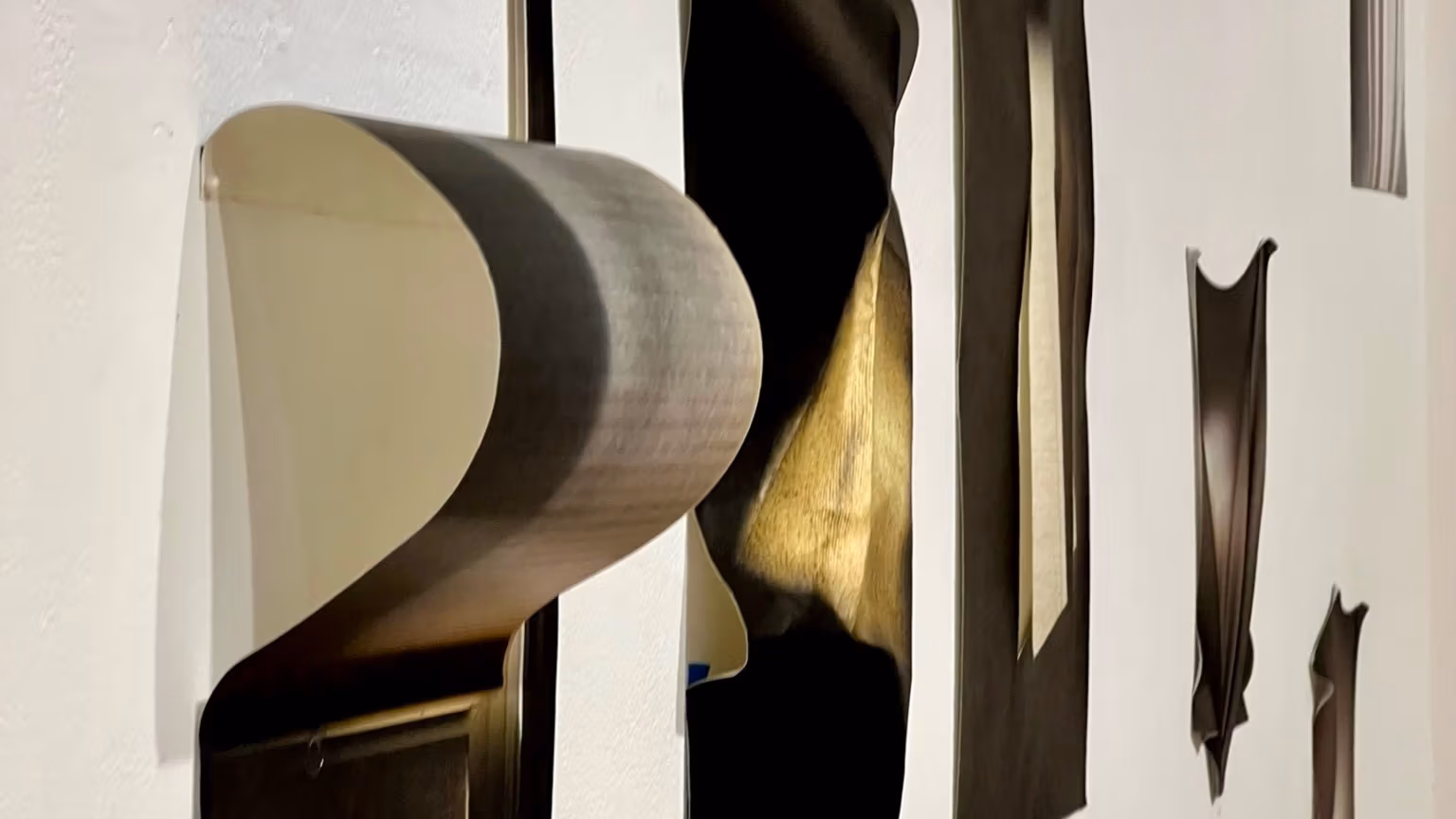 Photo of chiarascuro photographs hung protruding from a wall