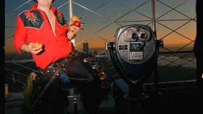 photograph of a woman in rodeo attire near a lookout