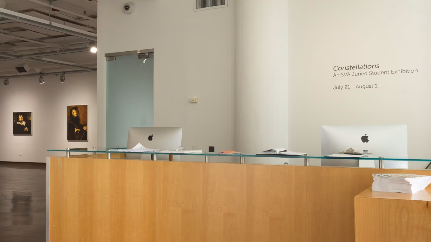 Photograph from entryway of SVA Chelsea Gallery with wall text stating "Constellations, An SVA Juried Student Exhibition, July 21 - August 11."