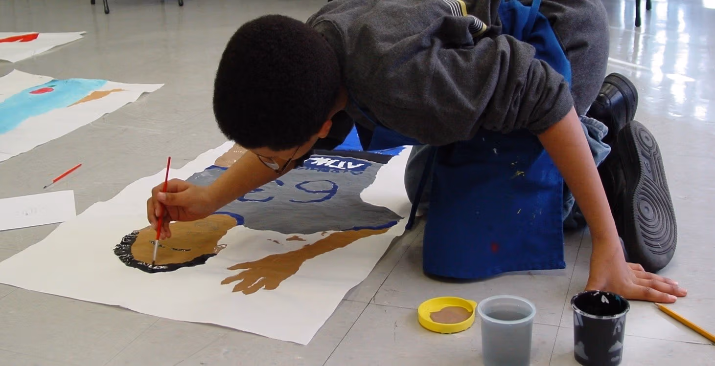 A man painting on a white paper.