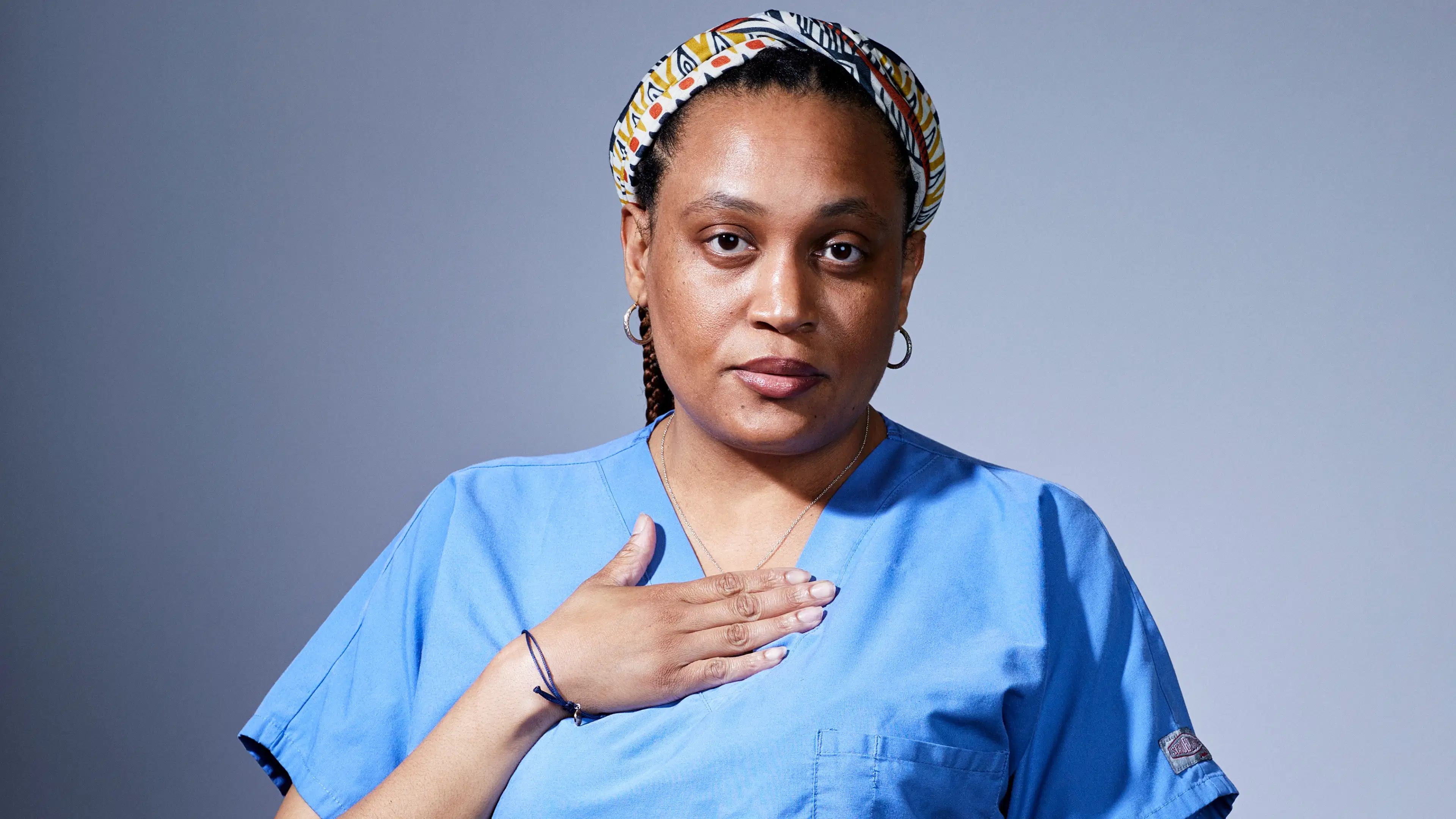 person with nurse uniform with hand over heart