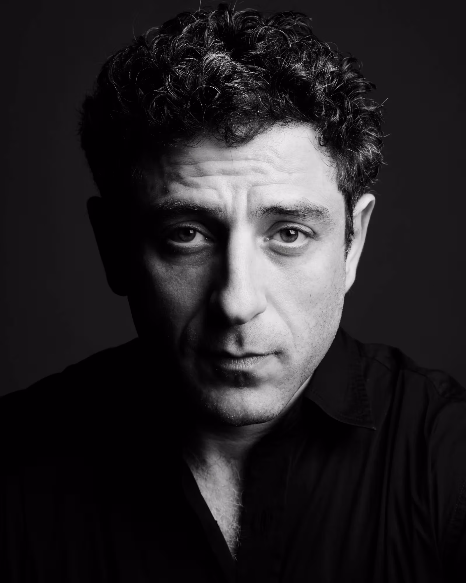 A headshot of Kon Trubkovich. The photograph is black and white. Kon is looking into the camera with a relaxed expression.