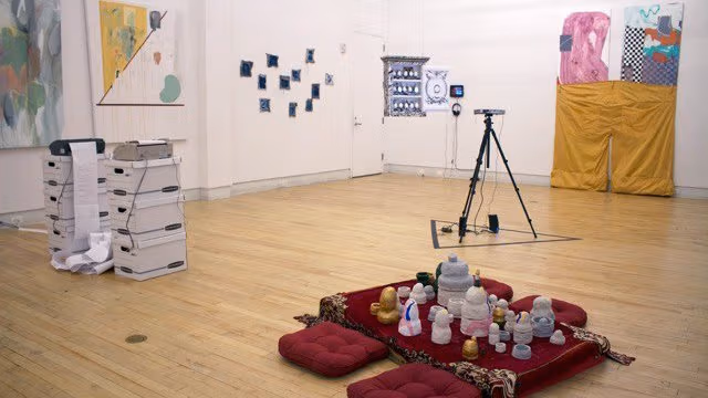 A room that features an eclectic collection of colorful paintings, pottery, old technology, and ceremonial seating arrangements.