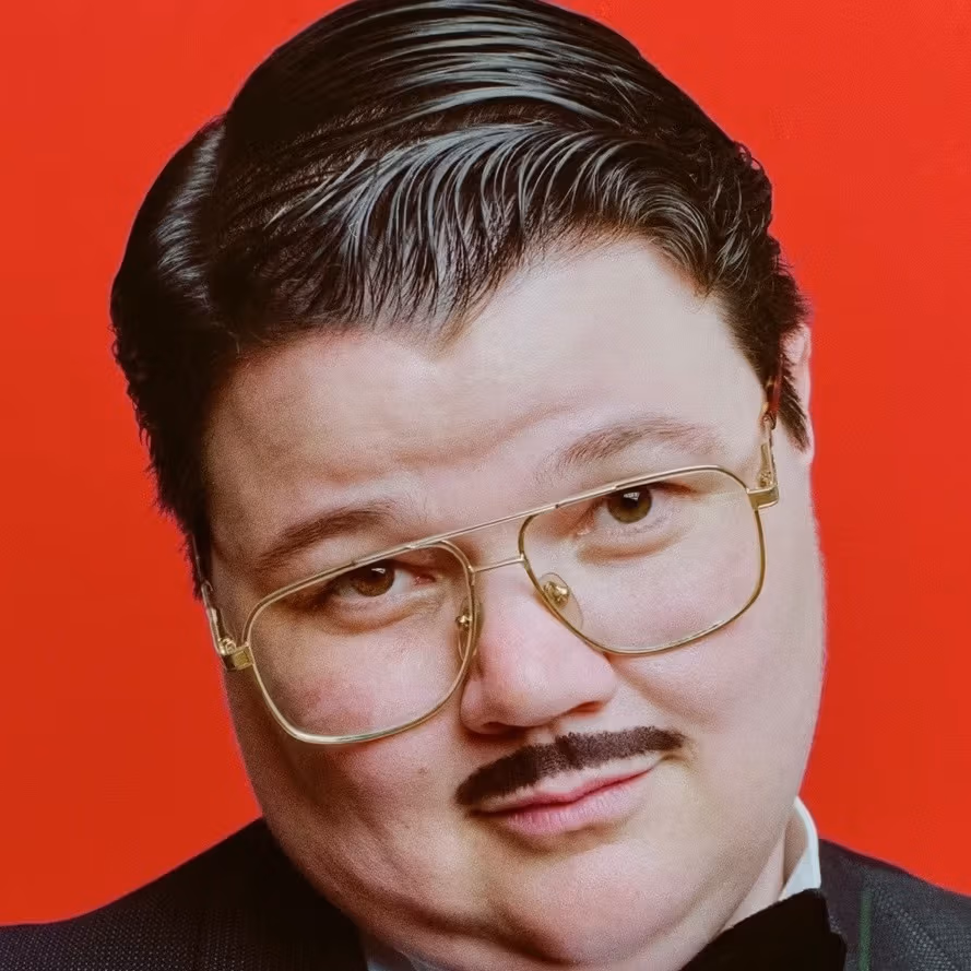 A portrait photograph of performer Murray Hill.