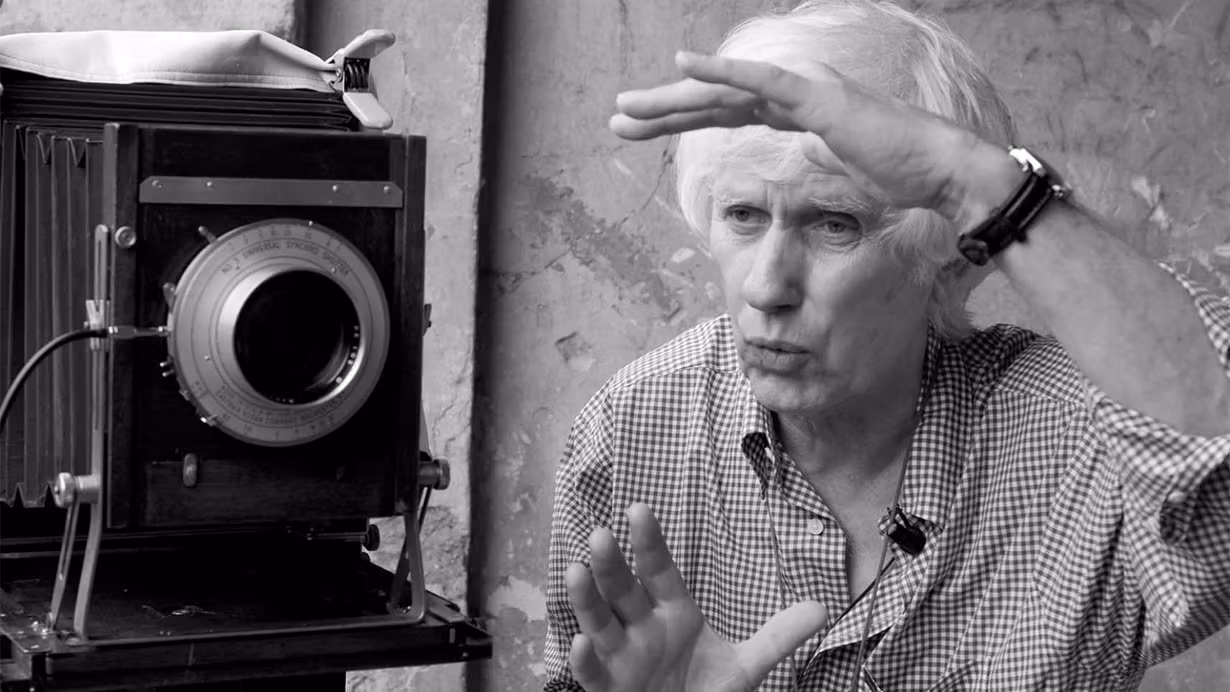 Man visualizes his next photo before capturing the image with his vintage camera.