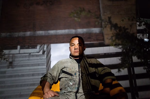 The man is sitting down outside