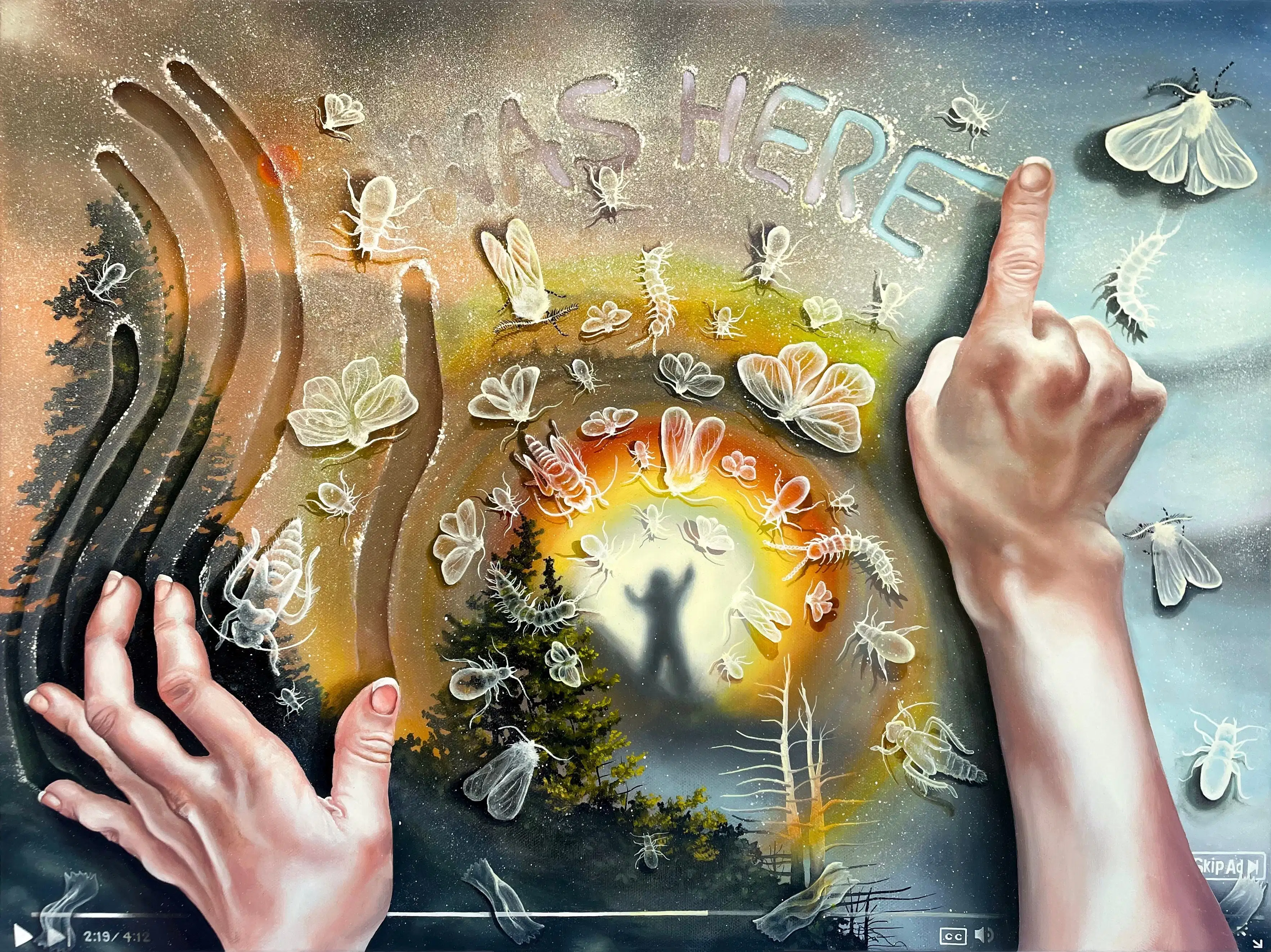 Two hands rest atop a surface, the left drawing vertical lines with their fingers, the right pointing creating the words "I Was Here" out of a sandy texture. Below this semi-transparent texture is a forested landscape with a figure standing atop a mountain as a rainbow radiates around them.