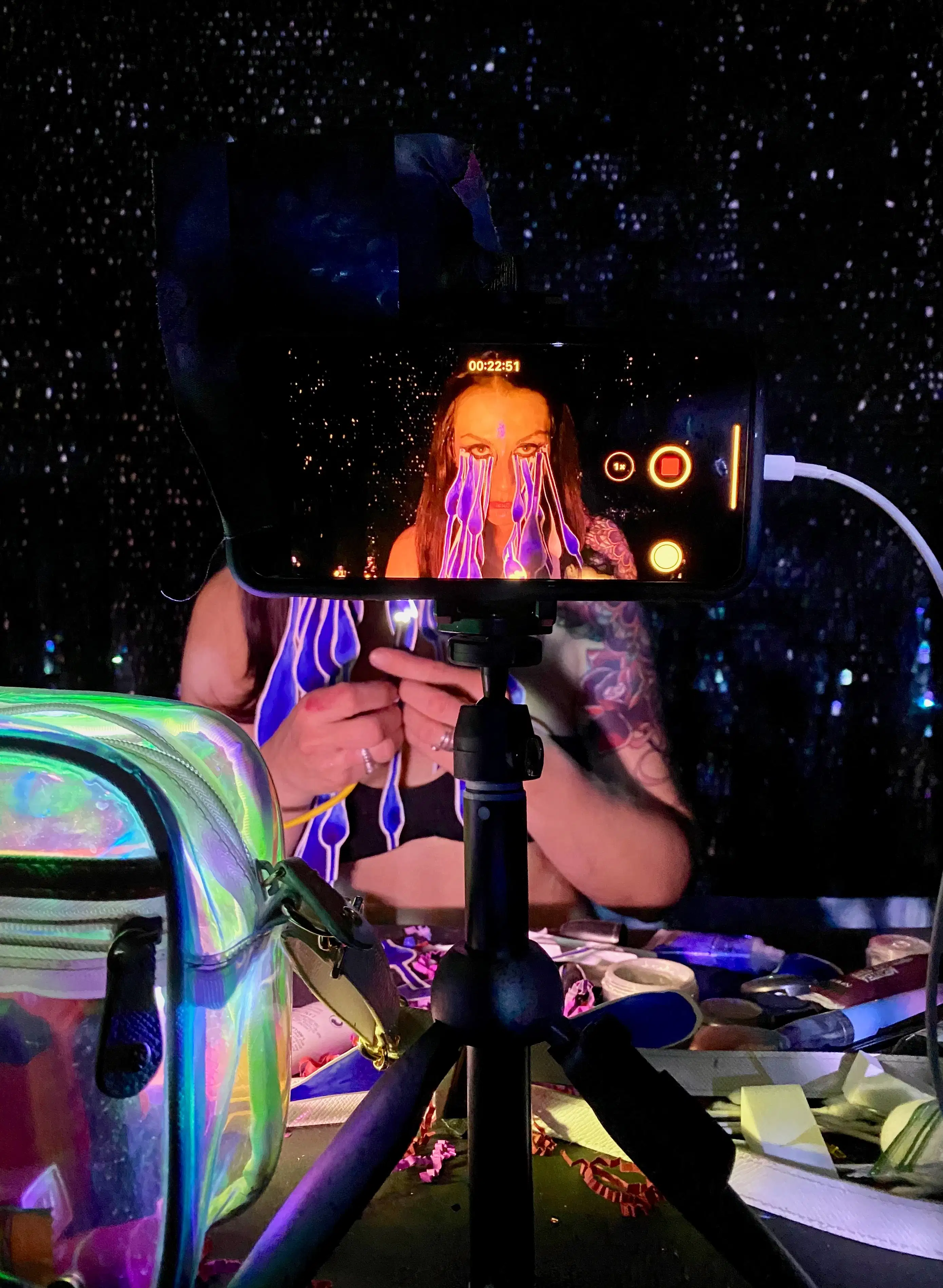 Photographic image of an iphone on a stand taking video of a woman.