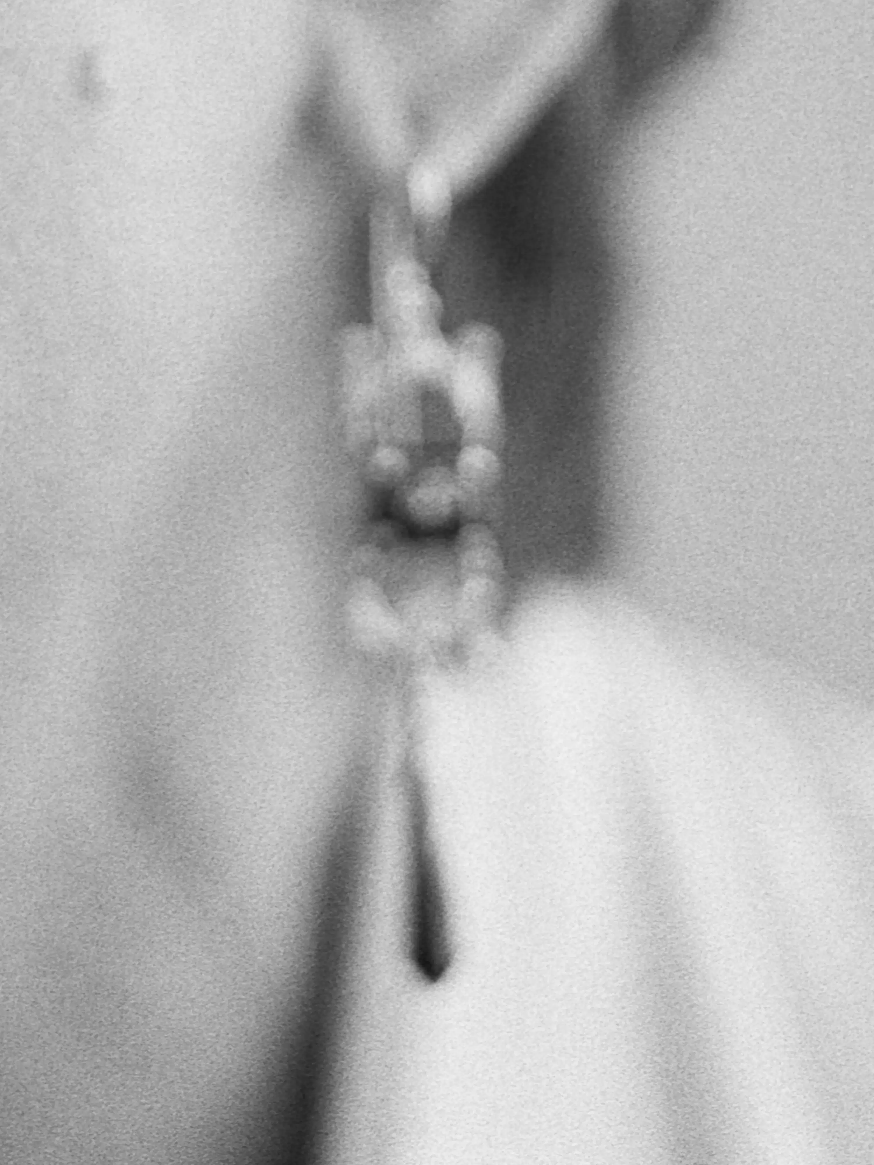 Blurry black and white photography of a dangling earring.