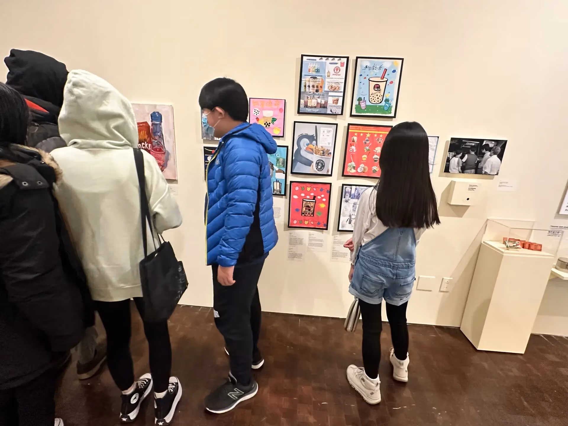 Picture of a few children looking at framed artwork at a museum exhibition.