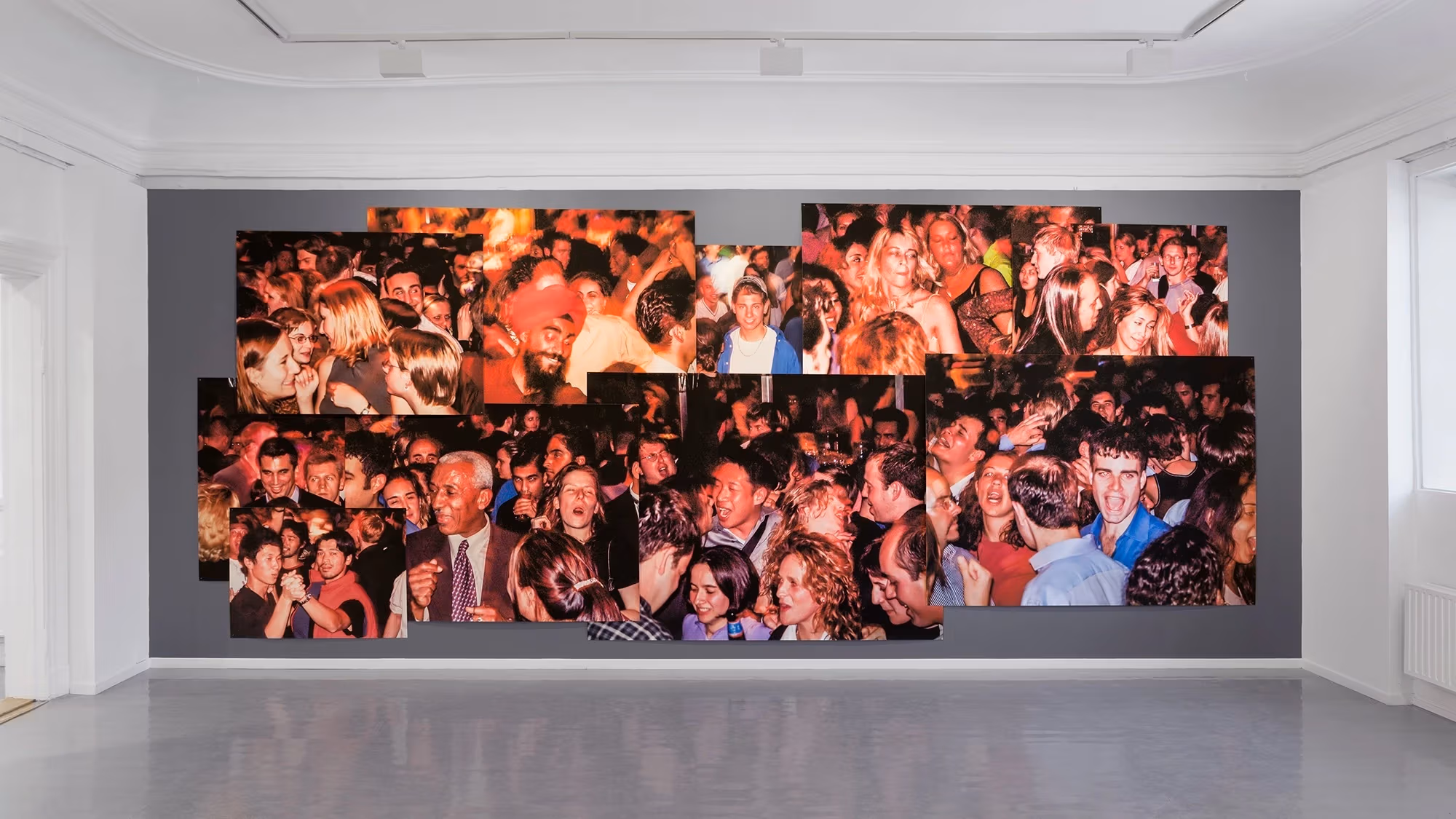 A installation photo of a mural consisting of Samaha's color photographs taken from the the 107th Floor of the World Trade Center, where he was a resident DJ for five years. The photographs depict crowds of people on a night out. 