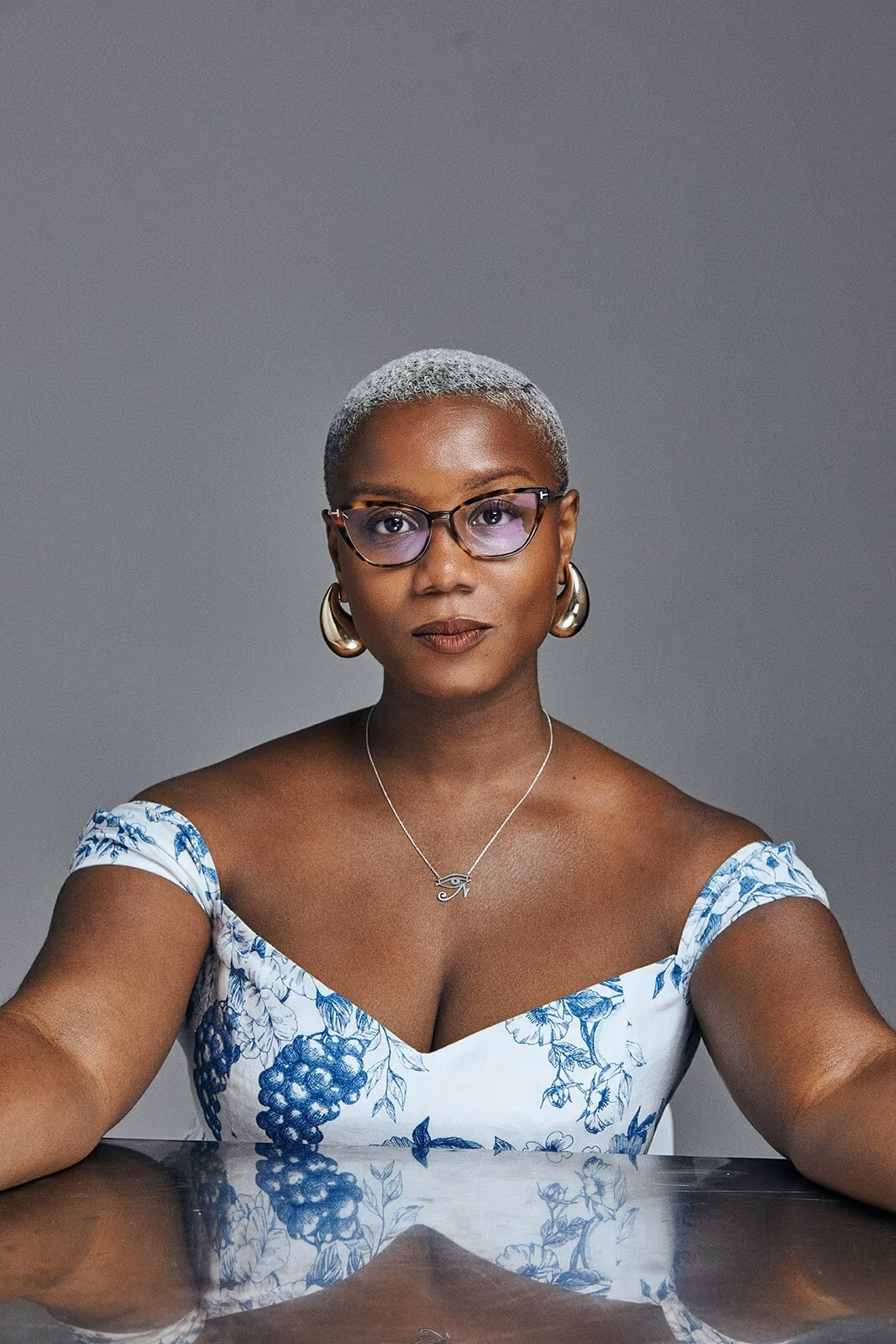 Portrait of a woman, Ja'Tovia Gary, posing in front of a reflective table. 