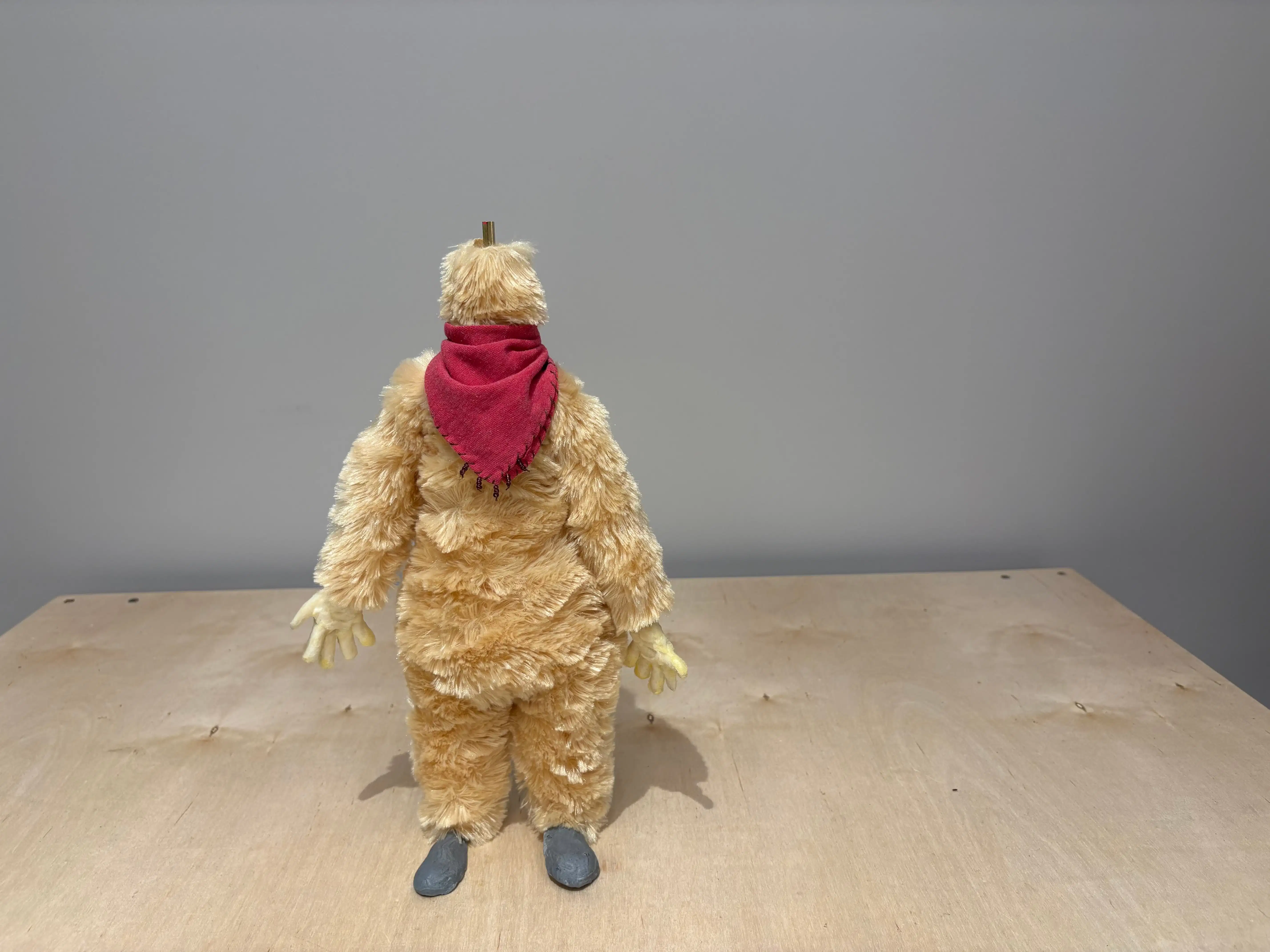 A furry puppet standing up with a red handkerchief on its neck