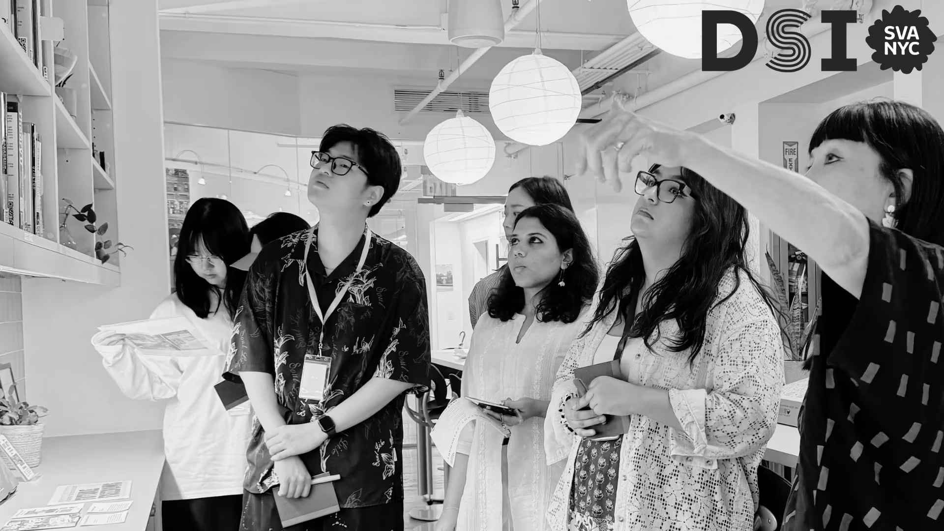Students looking up at library with instructor pointing