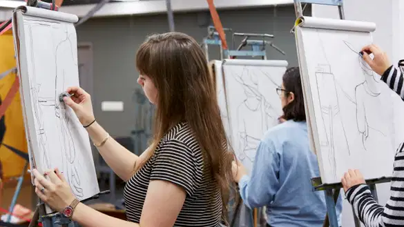 Students sketching on pads while standing up.