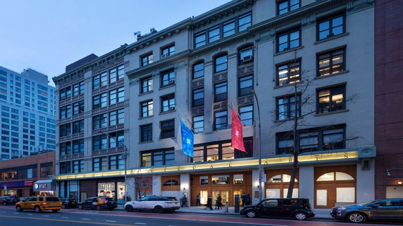 SVA's main building at dusk with two illuminated flags